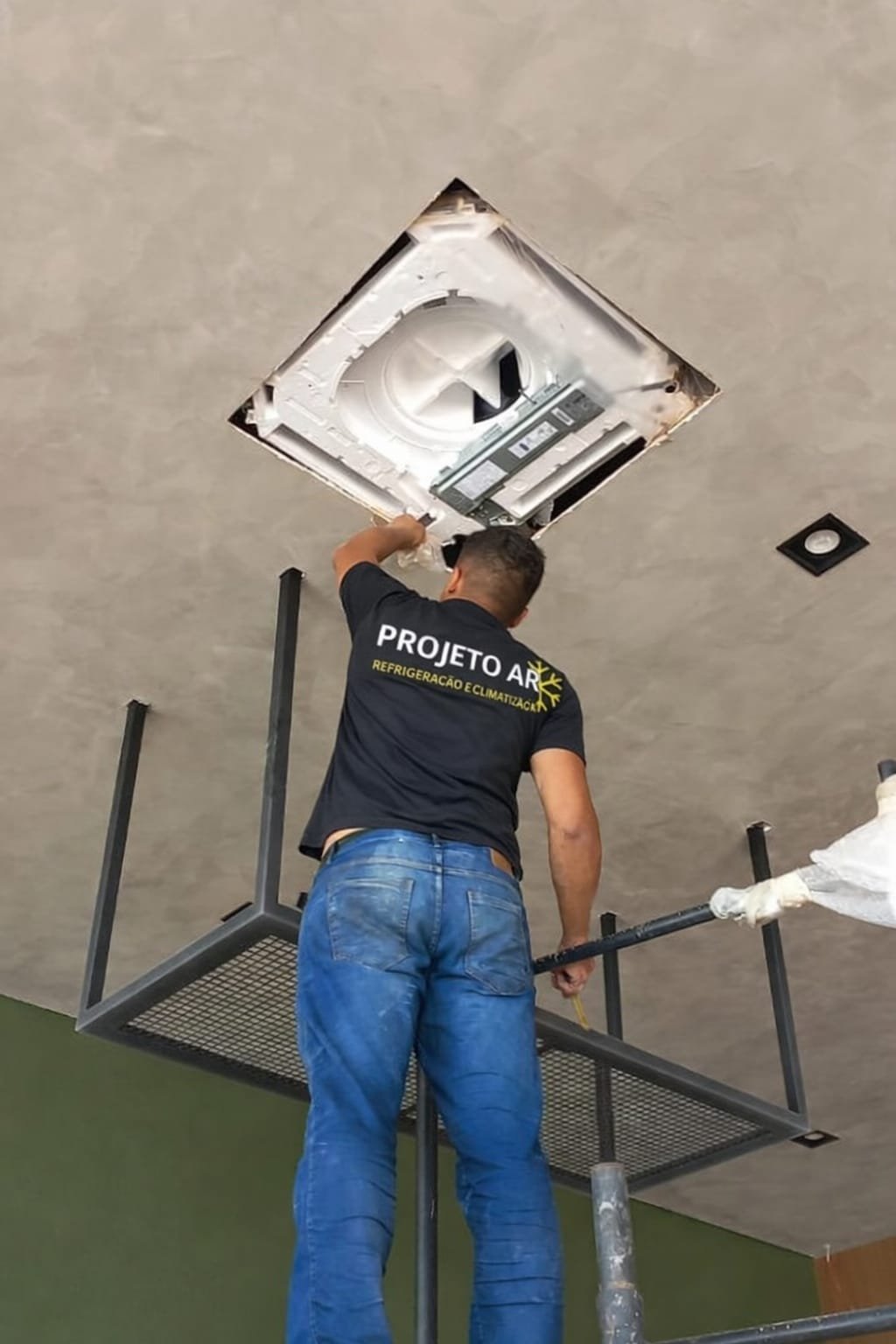 Técnico do Projeto Ar instalando ar-condicionado no teto